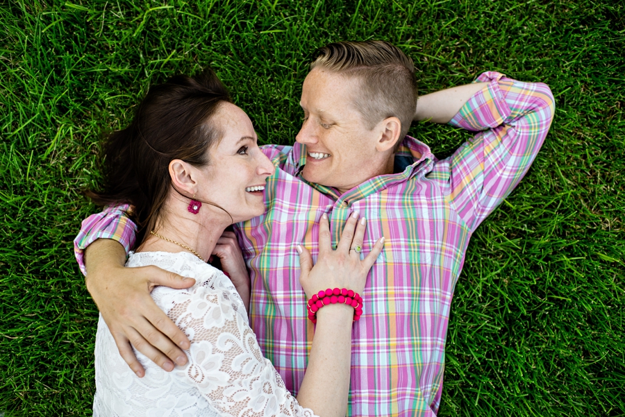 An engaged couple lay in the grass in a philadelphia park.